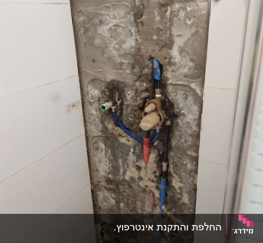 צנרת מים חשופה בקיר עם ברזים